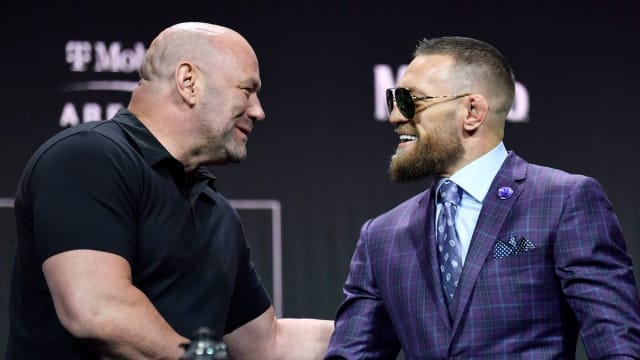 UFC President Dana White and Conor McGregor shake hands during a press conference.